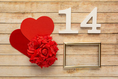 Close-up of red rose on wooden table