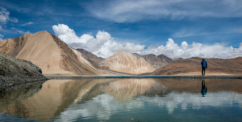 Scenic view of lake by mountains against sky