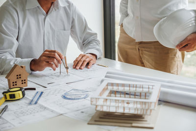 Midsection of business colleagues working on table