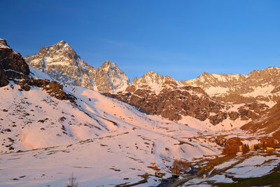 Scenic view of snowcapped mountains against clear blue sky