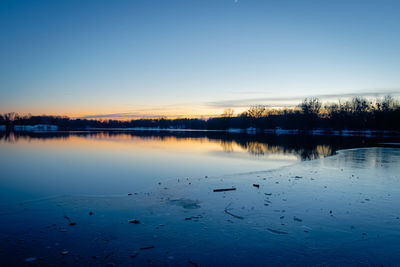 Scenic view of lake against clear sky during winter