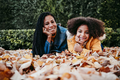 Portrait of smiling young woman with leaves during autumn