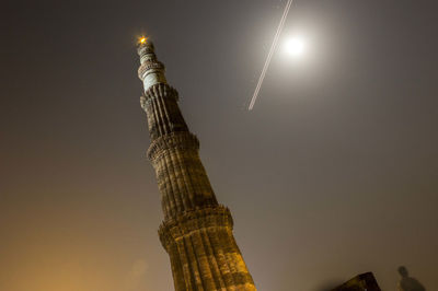 Low angle view of illuminated skyscraper against sky at night