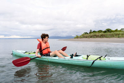 Teen relaxing in kayak in costa rica