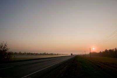 Road against clear sky during sunset