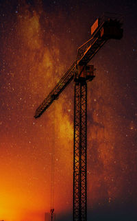 Low angle view of crane against sky at night