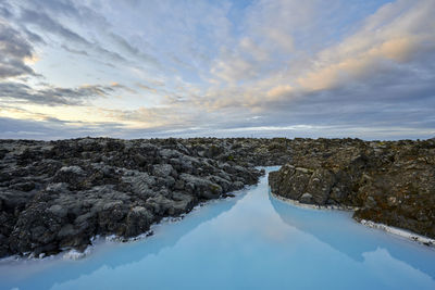 Scenic landscape of cloudy sky over blue lagoon at sunset