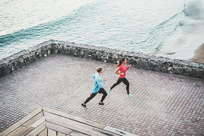 High angle view of friends jogging on promenade