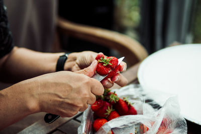 Close-up of hand holding strawberries