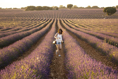 Rear view of woman walking on field