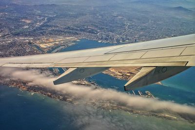 Cropped image of airplane flying over cityscape