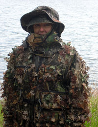 Portrait of army soldier standing against river