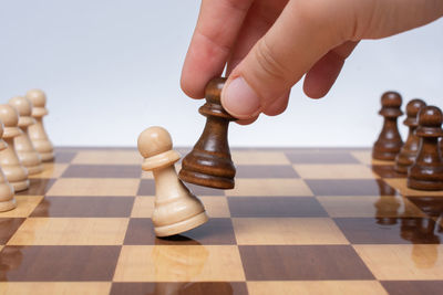 Cropped hand of man playing chess
