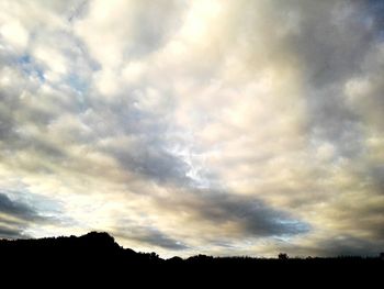 Silhouette of landscape against cloudy sky