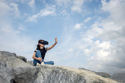 Woman wearing a vr headset reaching out to the sky.