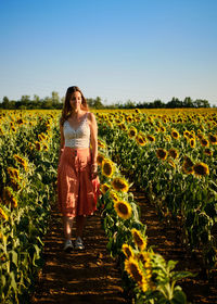 Rear view of woman standing on field against clear sky