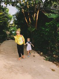 Rear view of mother and daughter on tree