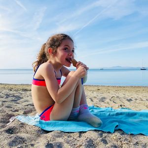 Girl holding ice cream cone at beach