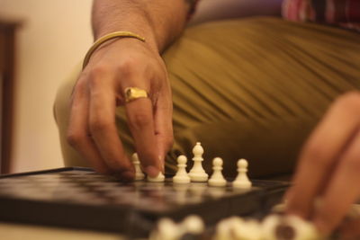 Midsection of man playing chess at home