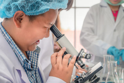 Boy using microscope in laboratory