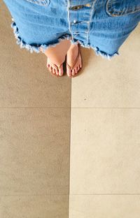 Low section of woman standing on tiled floor