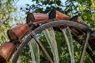 Old rusty bicycle on field against trees