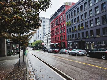 Cars on street by buildings in city