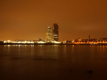 Illuminated city at waterfront at night