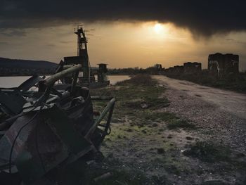 Old car on field against sky during sunset