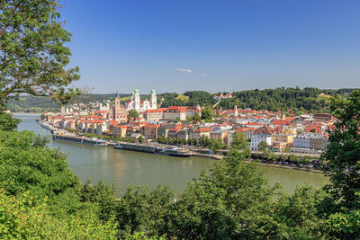 River amidst townscape against clear blue sky