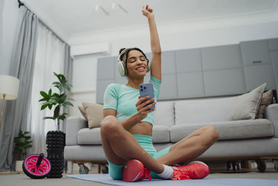 Side view of woman exercising on sofa at home