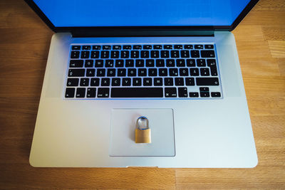 Close-up of padlock on laptop at table