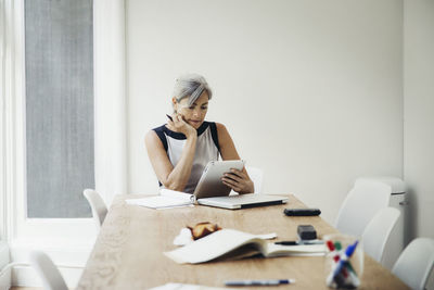 Businesswoman using tablet computer in board room