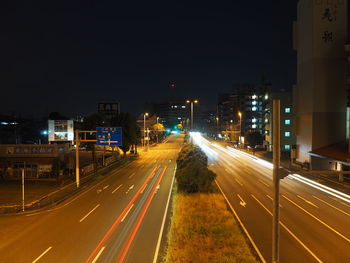 Illuminated light trails on road in city at night