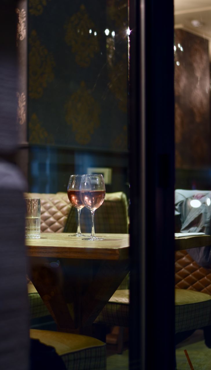 CLOSE-UP OF DRINKING GLASS ON TABLE