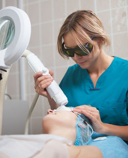 Close-up of woman getting beauty treatment from doctor