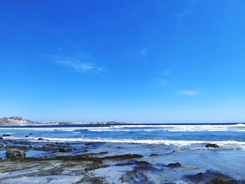 Scenic view of sea against blue sky