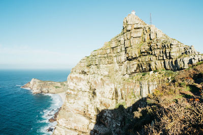 Rock formations by sea against sky