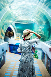 Rear view of woman standing in aquarium