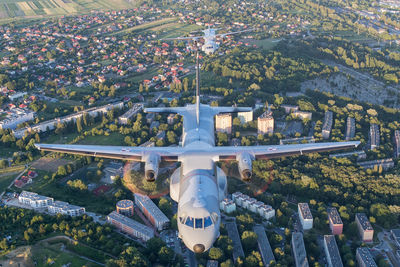 High angle view of airplane flying over buildings in city