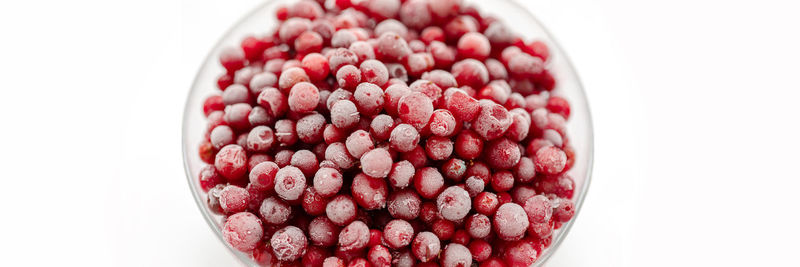 Directly above shot of hearty red frozen berries on white background.