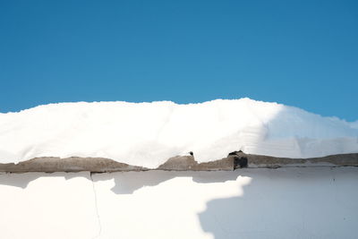 Scenic view of snowcapped mountains against clear blue sky