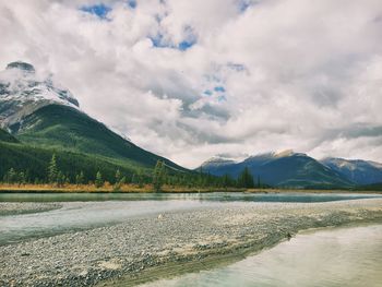 Scenic view of lake by mountains against sky