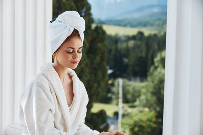 Young woman standing by window