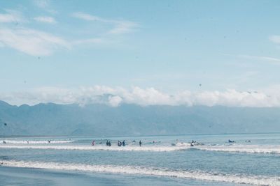 People at beach against sky