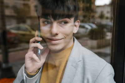 Portrait of happy man holding mobile phone