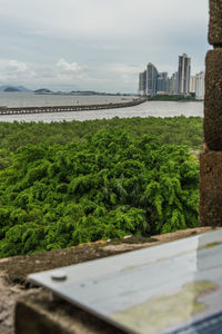 Scenic view of land by buildings against sky