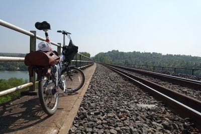 Bicycle on railroad tracks against clear sky