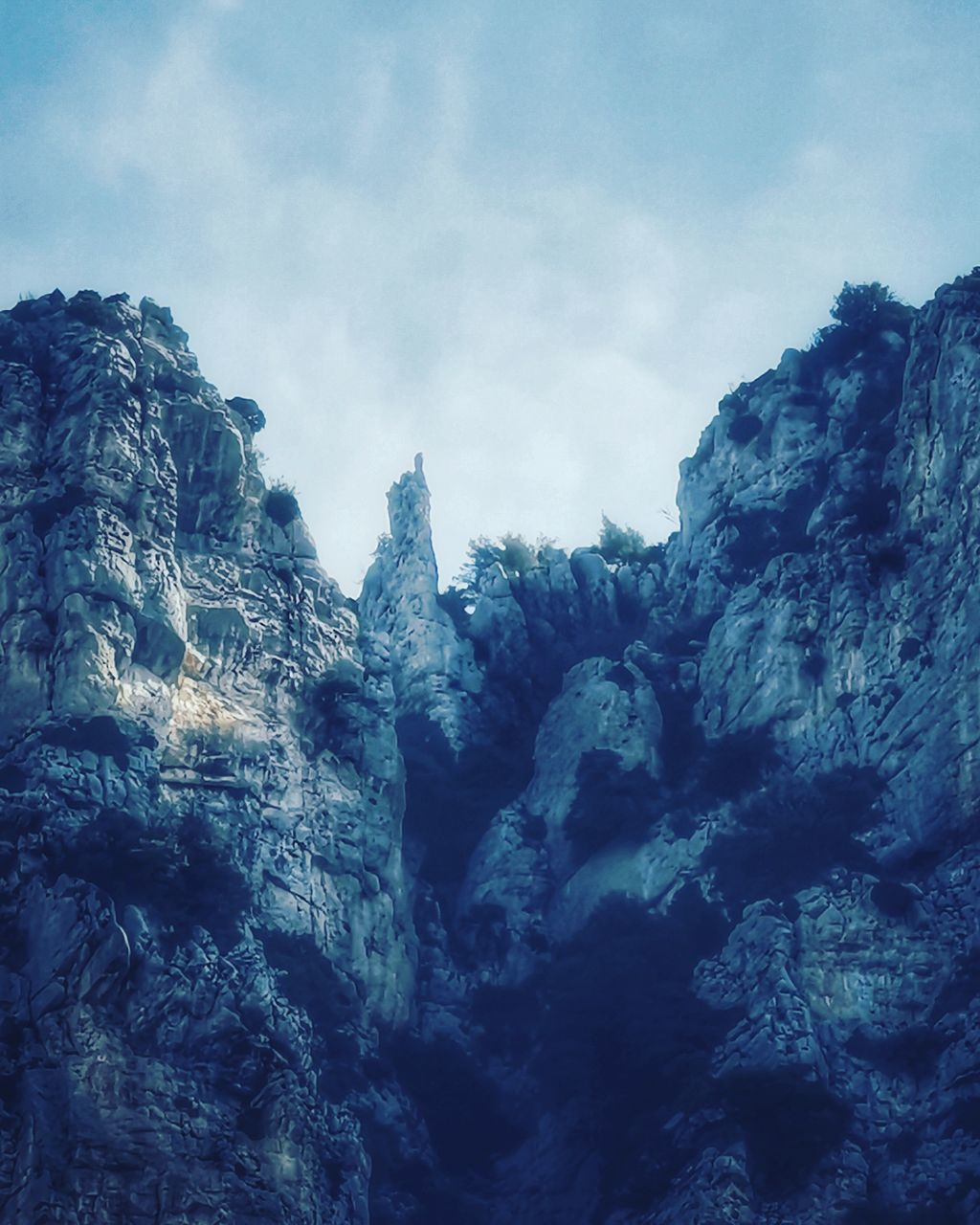 LOW ANGLE VIEW OF ROCK FORMATIONS AGAINST SKY