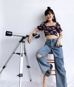 Portrait of woman sitting next to telescope 